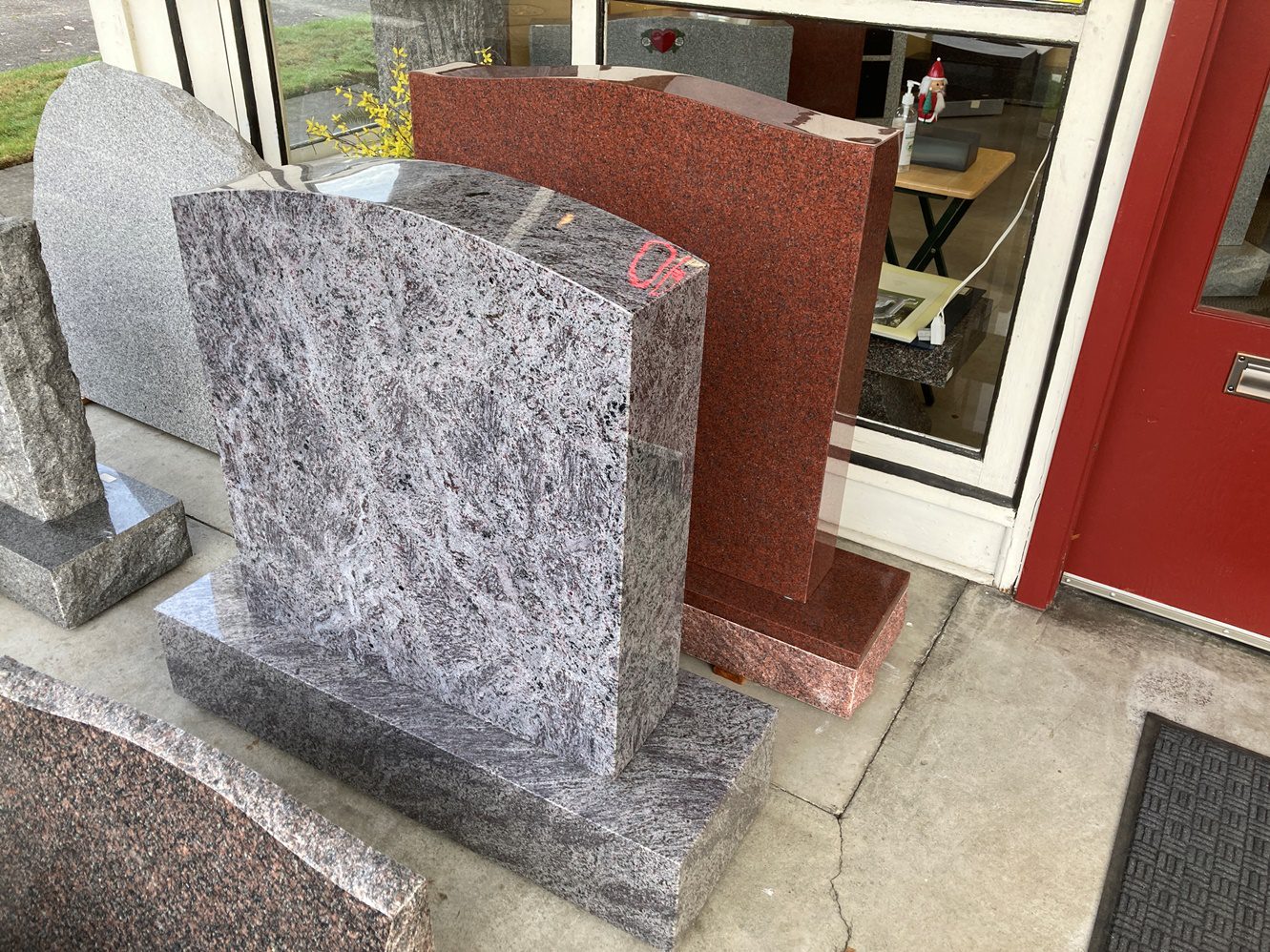 A gray and red granite tombstone